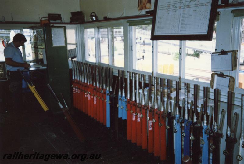 P12090
Signal box, internal view showing the signalman and levers, Narrogin, GSR line. 
