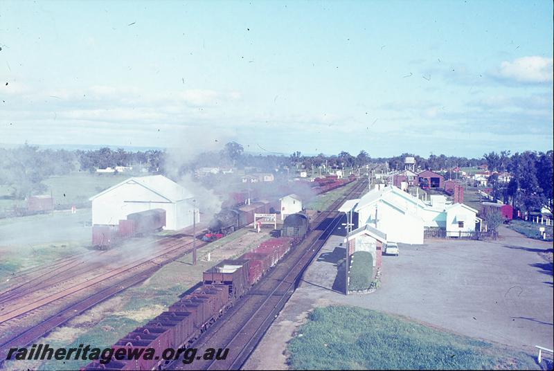 P12275
PM class 718, 37 goods, arriving Pinjarra, PMR class on 34 goods in back platform, PMR class 724 in Pinjarra loco shed, station buildings, platform, goods shed, from water tower. SWR line.
