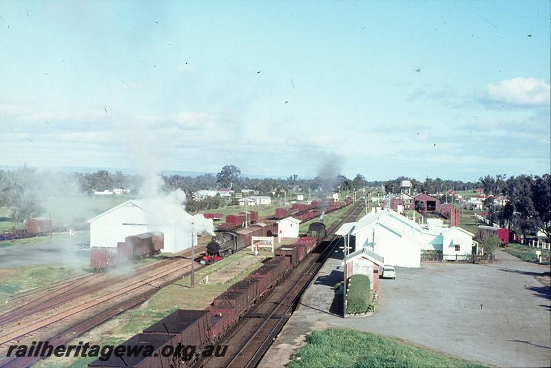 P12276
PM class 718, 37 goods, arriving Pinjarra, PMR class on 34 goods in back platform, PMR class 724 in Pinjarra loco shed, station buildings, platform, goods shed, from water tower. SWR line.
