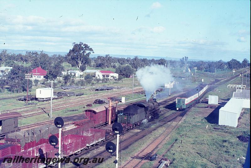 P12279
ADF class on Bunbury Belle, ADU class carriages in the Green and white with the red stripe livery but with plain green end, departing, passing PM class 718 on 37 goods, internal view of the four wheel open wagons, two brakevans, one the green livery, the other in the brown livery, searchlight signals, ganger's sheds, junction to Dwellingup in distance, elevated view from southern water tower. Pinjarra, SWR line.
