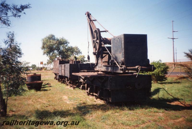 P12569
Cowans Sheldon six wheel crane coupled to an open wagon and a G class tender, Port Hedland, side and counter weight end view. Items now located in the Don Rhodes Museum in Port Hedland
