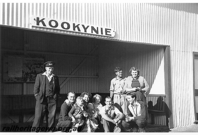 P14221
Station building, Kookynie, KL line, in front of the building are train guard Hyde, Driver Gordon Fraser squatting. schoolteacher Raymond Omedei squatting at far right.
