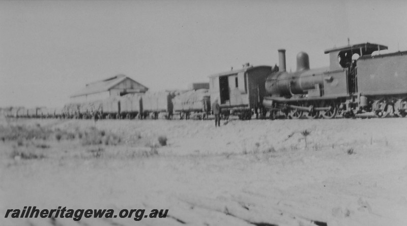 P14497
G class 156?, four wheel brakevan on train of wagons loaded with bagged wheat, Esperance, CE line, view form loco along the tran.c1925/26

