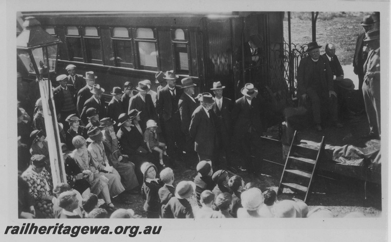P14504
Crowd assembled in front of a platform ended carriage for the official opening of the Esperance to Salmon Gums Railway, CE line oil station lamp in the view
