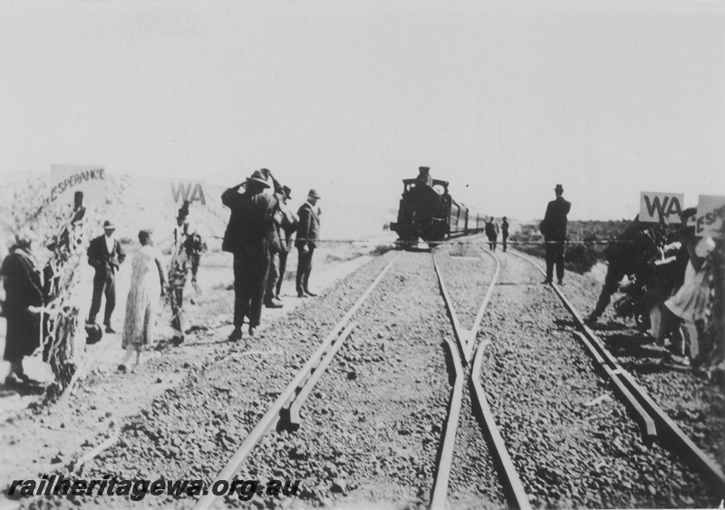 P14505
The first train arriving at salmon Gums, CE line, from Perth for the official opening of the line from Salmon Gums to Esperance, trackside signs and a ribbon across the line
