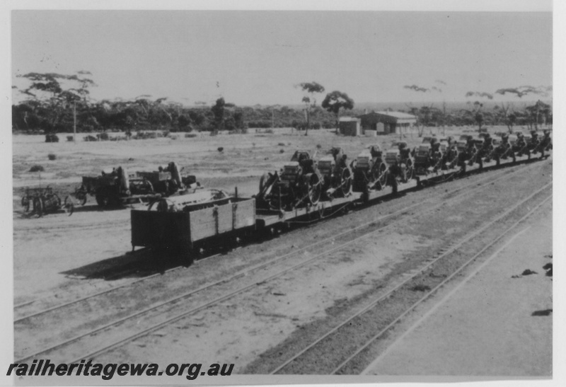 P14506
Bogie and four wheel wagons loaded with harvesters, Salmon Gums, CE line, harvester repossessed from farmers unable to meet commitments due to the downturn in agricultural, view along the line of wagons.
