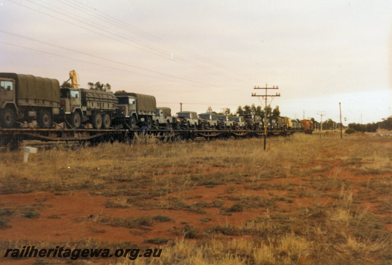 P14516
3 of 4 photos of probably the last military train movement of a unit in Western Australia. 13 field Squadron RAE Army Reserve travelled from Kewdale Yard to Morawa, Photos taken at Morawa, EM line, view along the train showing the military vehicles on the flat wagons.
