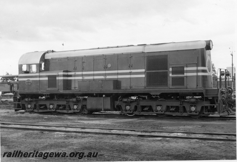 P15387
F class 45 diesel locomotive with a blank circle on the nose. The locomotive is pictured at Midland Workshops with portion of an unidentified steam locomotive in the background.
