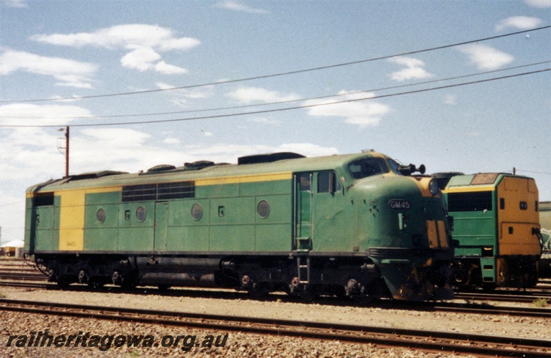 P15580
Australian National GM class 44, green livery with a yellow stripe on the nose and a yellow panel on the side, Parkeston, side and front view.
