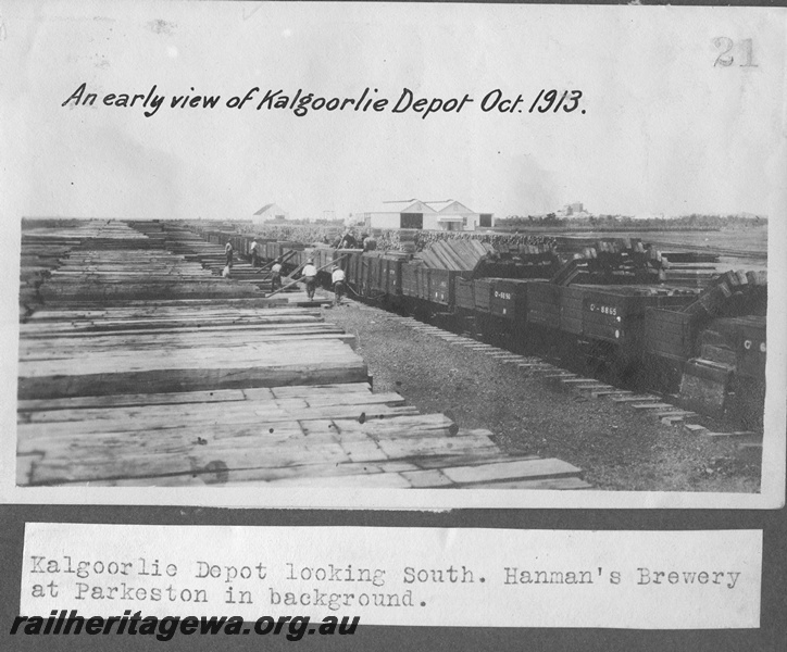 P16179
Commonwealth Railways (CR), rake of wagons including C class 8865 and C class 6690, loaded with sleepers, workers, piles of sleepers, shed, Kalgoorlie depot, Hannans Brewery in background at Parkeston, TAR line, view looking south
