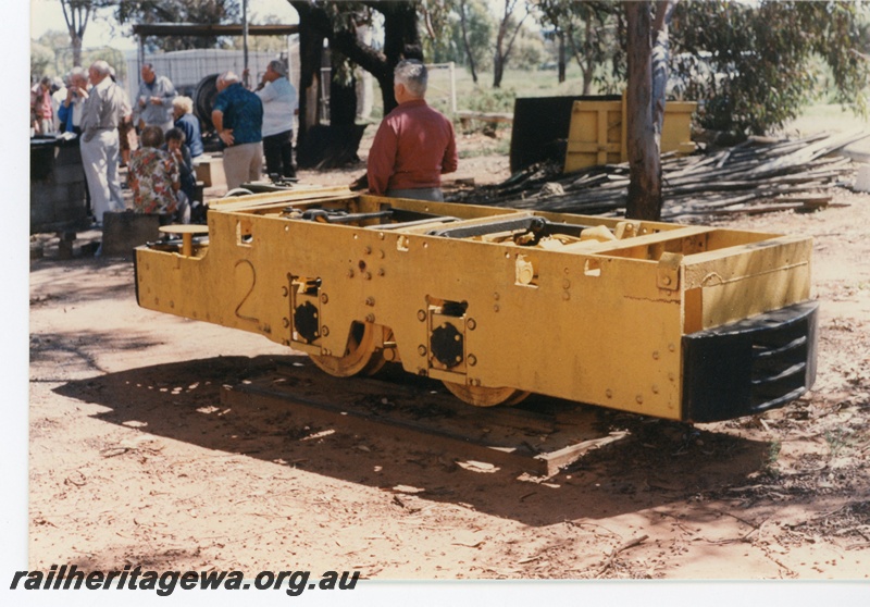 P16520
Motorised mine trolley, yellow, in preservation at Norseman museum, barbecue taking place nearby, side and end view
