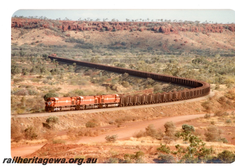 P16745
Mount Newman (MNM) triple headed 180 car loaded ore train at 227 km near Garden loop. 

