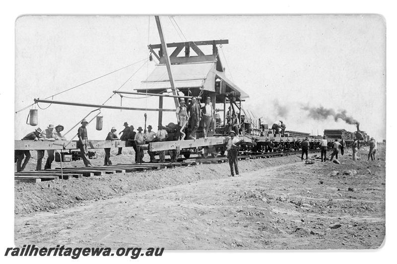 P16802
Commonwealth Railways (CR) - TAR line track laying machine with G class steam locomotive at rear of train. c1916
