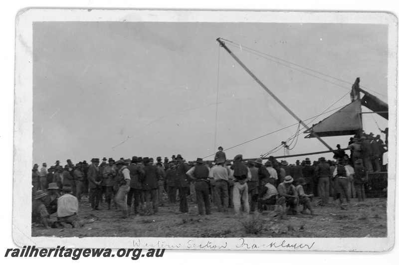 P16805
Commonwealth Railways (CR) - TAR line track laying machine -side view showing large gathering of people watching . c1916
