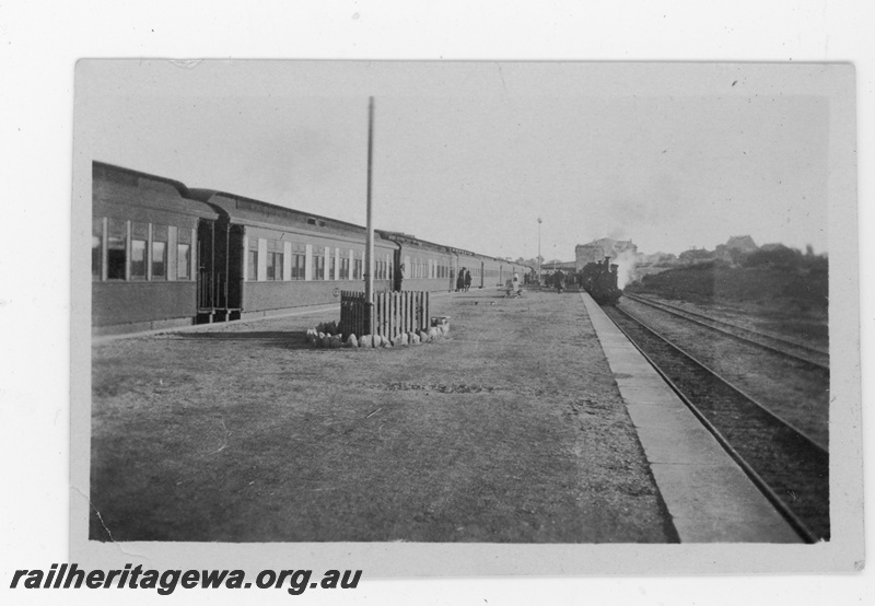P16850
Commonwealth Railways (CR) - TAR line Port Augusta Station view from south end of platform. Trans train on left and narrow gauge steam hauled passenger in dock platform. C1930
