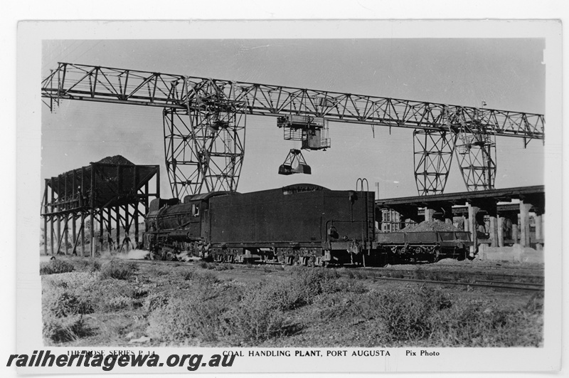 P16854
Commonwealth Railways (CR) - TAR line C class steam locomotive (fitted with smoke deflectors) at the coal loading facility Port Augusta locomotive depot. Rear view of locomotive..
