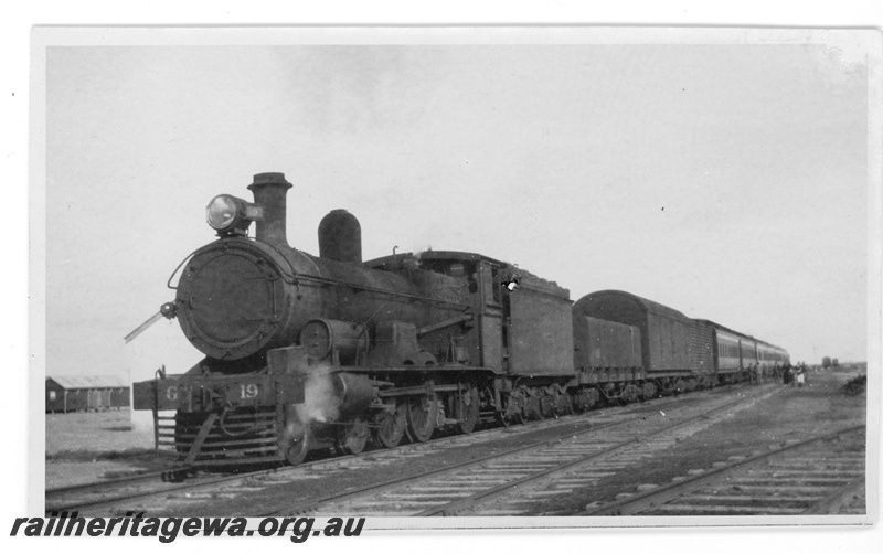 P16888
Commonwealth Railways (CR) - TAR line G class 19 steam locomotive hauling Transcontinental express at an Unknown location. 
