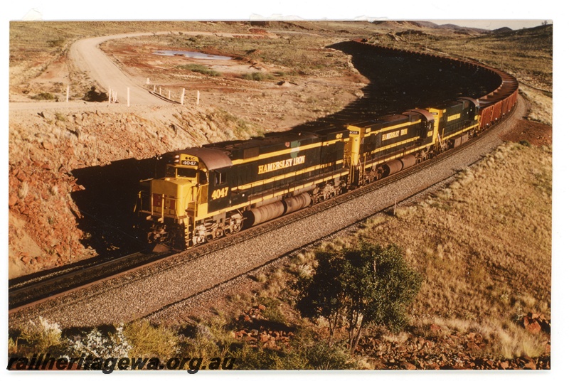 P16959
Hamersley Iron M636 class 4047, M636 class 3038 and C36-7 class 5056, all in green and gold livery, triple heading empty iron ore train, near Emu siding Hamersley line, Pilbara,
