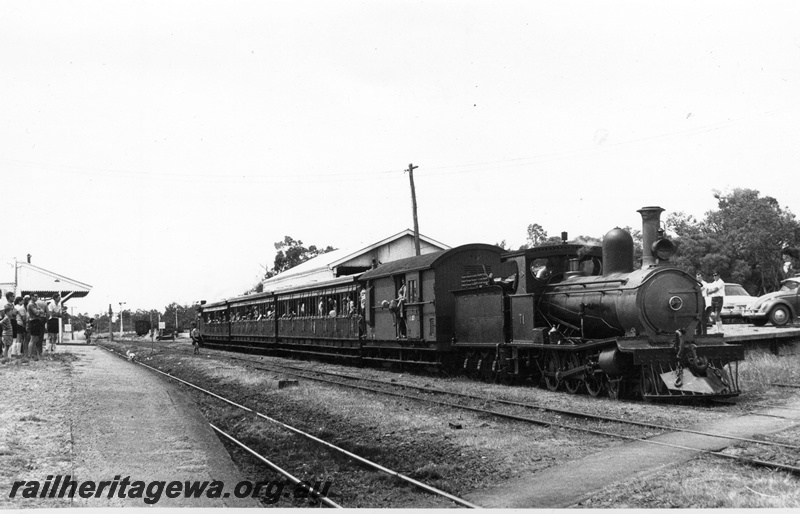 P17137
G class 71 locomotive at Yarloop at the head of the Vintage Train prior to entering the Yarloop Workshops complex. Front & side view of loco. Yarloop Station platform & building on left and portion of goods shed on right background. SWR line.

