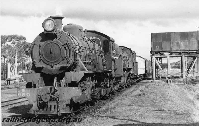 P17142
W class 960 and PR class 526 locomotives at the head of No. 12 Goods train at Yornaning. Water tower to left of train and portion of livestock loading ramp at left. GSR line.
