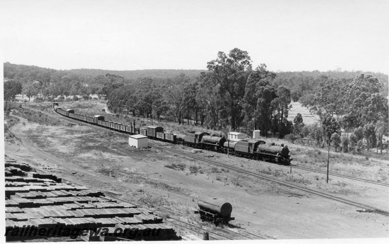 P17383
W class 919 & W class 914 steam locomotives approaching Bowelling Junction with 54 Goods from Wagin. WB line. Note water tanker and sleeper stacks in foreground. 
