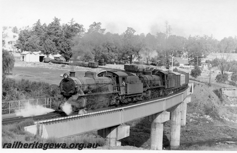 P17444
W class 942 & 934 steam locomotives working a Bridgetown - Bunbury goods train crossing the Balingup Bridge. PP line. Front & side view of the lead loco. Partial side view of rear locomotive and side/distant view of freight vehicles. South bound train noted in loop of station. 
