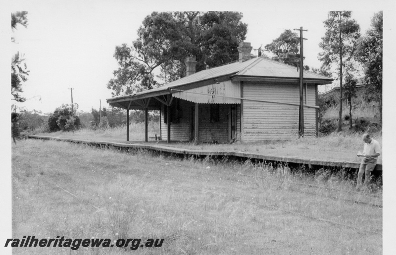 P17570
Station building, passenger platform, view of east end and front, SM's house in the background, Mundaring, M line.
