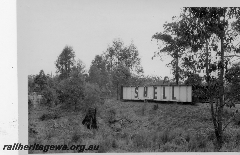 P17573
2 of 2 The girder span after being removed from Mundaring-Sawyers Valley flyover, abutments in the distance, advertising on the side of the girder, M line.
