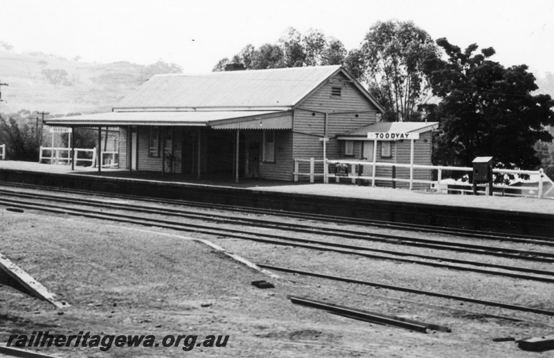 P17577
Station building, track-side view, nameboard, fire hydrant, loading bank, Toodyay, CM line.
