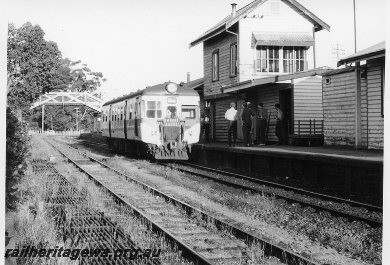P17590
Unidentified ADG type suburban railcar at Chidlow. ER line. Note signal box and other buildings on platform, overhead footbridge in background.
