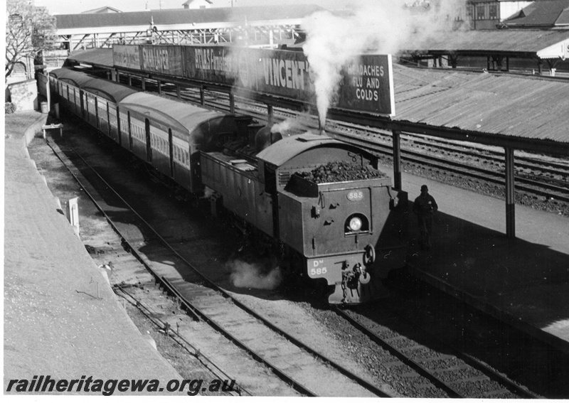 P17638
DM class 585 steam locomotive about to depart with the Perth to Cannington suburban service from the Armadale Dock at City Station. ER Line. Partial view of rear of tender. Note overhead advertising on roof guttering edge.
