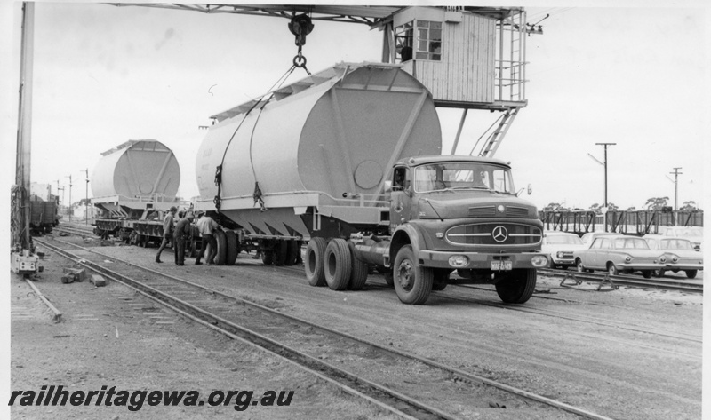 P17844
Parkeston and new WW class wheat hopper wagons being unloaded from Commonwealth Railway flattop wagons. Note the method used for road transport of these wagons to West Merredin yard.
