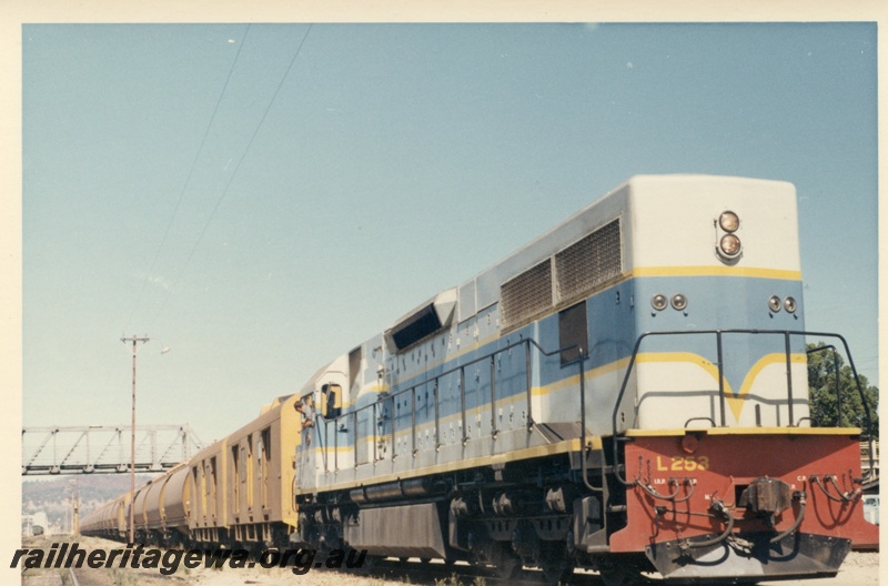 P17994
L class 253 on train of empty wheat wagons, steel overpass, Midland, ER line

