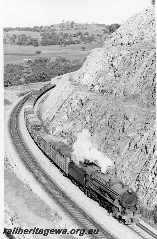 P18212
2 of 2, V class 1215 steam locomotive, elevated front and side view, on the No.24 goods train, Windmill Hill Cutting, Avon Valley line.
