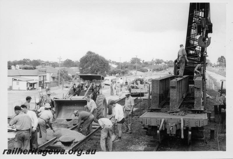 P18236
Cowans Sheldon Breakdown crane No. 31 placing girders onto a flat wagon, demolition of the West Midland station and subway, view along the track looking west.

