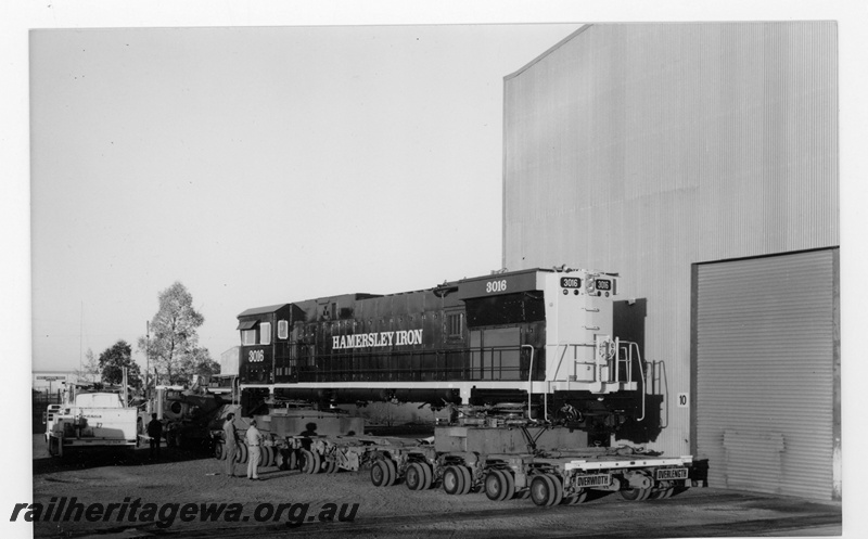 P18885
Hamersley Iron (HI) C636R class 3016 on low loader at Comeng Bassendean works ready for departure to Dampier after rebuilding with Pilbara cab. Rear view
