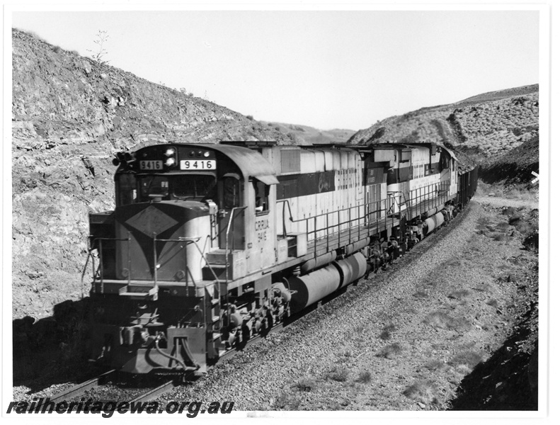 P18922
Cliffs robe River (CRRIA) M636 class 9416 leads a loaded iron ore train through 86kp canyon.
