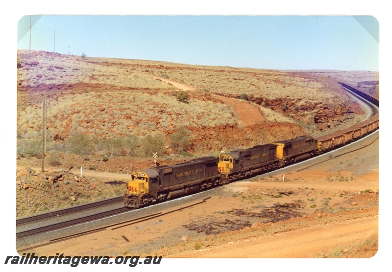 P18954
Hamersley Iron (HI) M636 class haul a loaded iron ore train near Emu.
