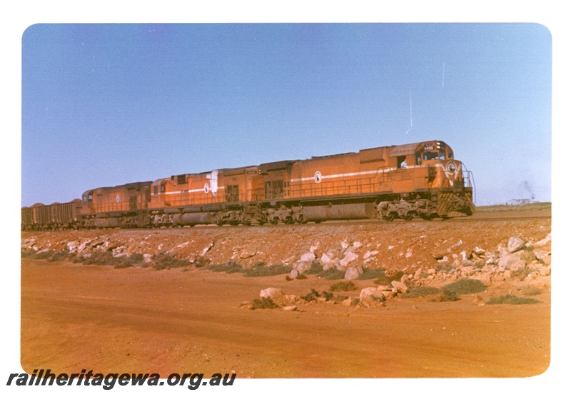 P18963
Mount Newman (MNM) M636 class 5499 and 2 unidentified locomotives haul a loaded iron ore train between Newman and Port Hedland. 
