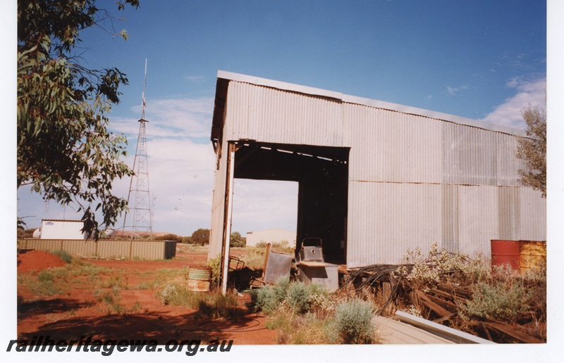 P18989
Goods shed, Sandstone, NR line, abandoned and surrounded by trash, end view.
