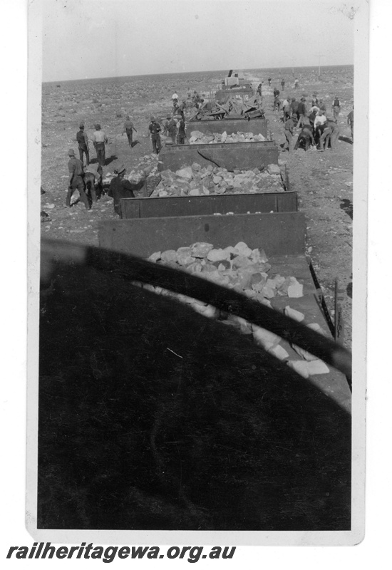 P19013
Construction of TAR line by Commonwealth Railways (CR), construction train, wagons laden with rocks, workers, desert scene, TAR line, c1914
