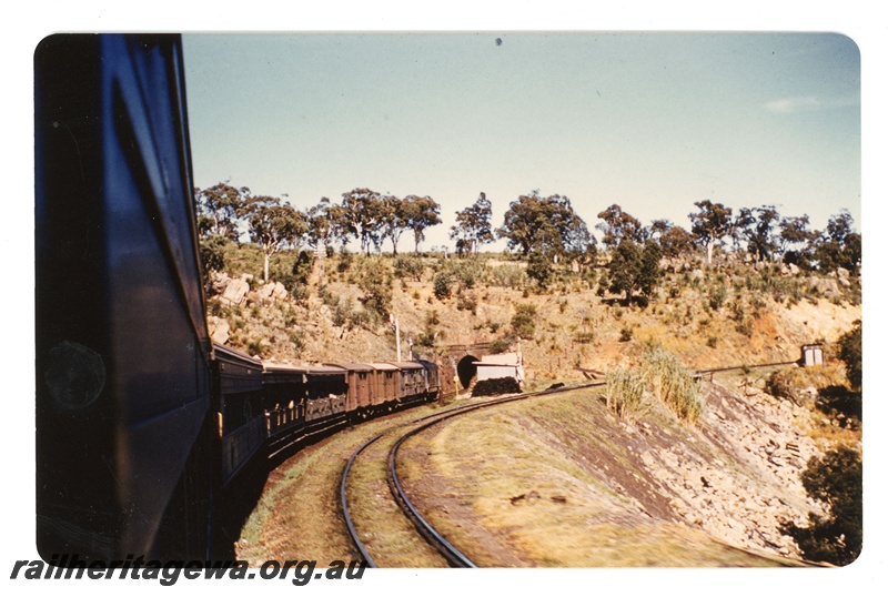 P19135
X class hauled passenger train entering the Swan View tunnel - eastern end. Photo taken from passenger carriage with a view looking along the train. ER line.
