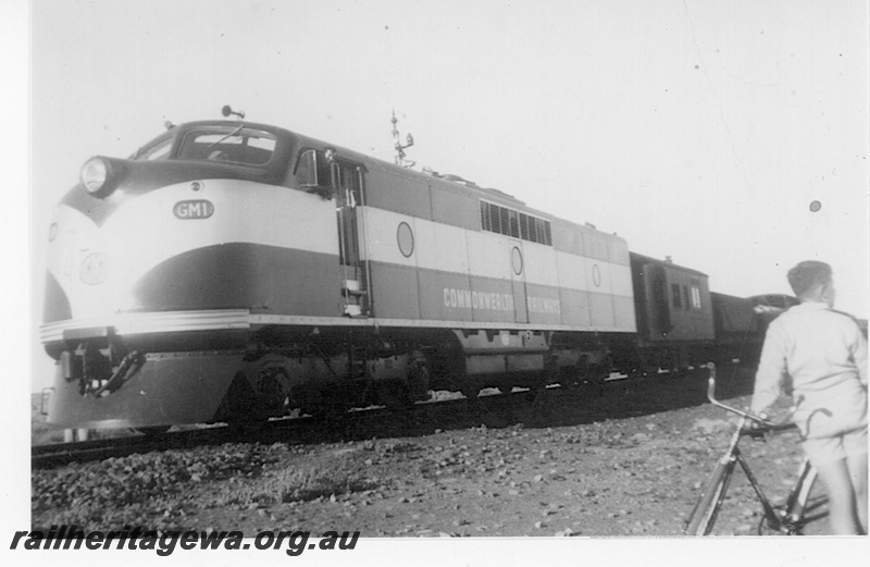 P19189
Commonwealth Railways (CR) GM class 1 on goods train, boy (Robert Campbell-Foulkes) with bicycle, signal, Forrest, TAR line, first diesel to cross the Nullarbor
