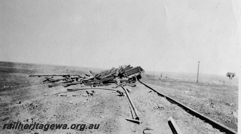 P19190
Commonwealth Railways (CR) construction train derailment, flat wagon with sleepers off track, rail torn up, TAR line,

