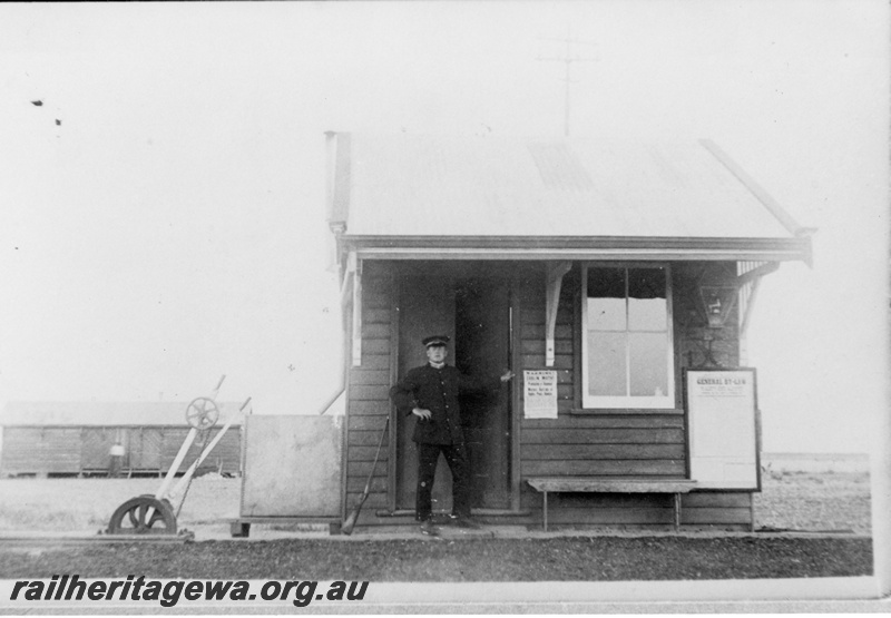 P19191
Commonwealth Railways (CR) station building with uniformed station master A. Rees standing in front, point levers, house in background, Barton, TAR line
