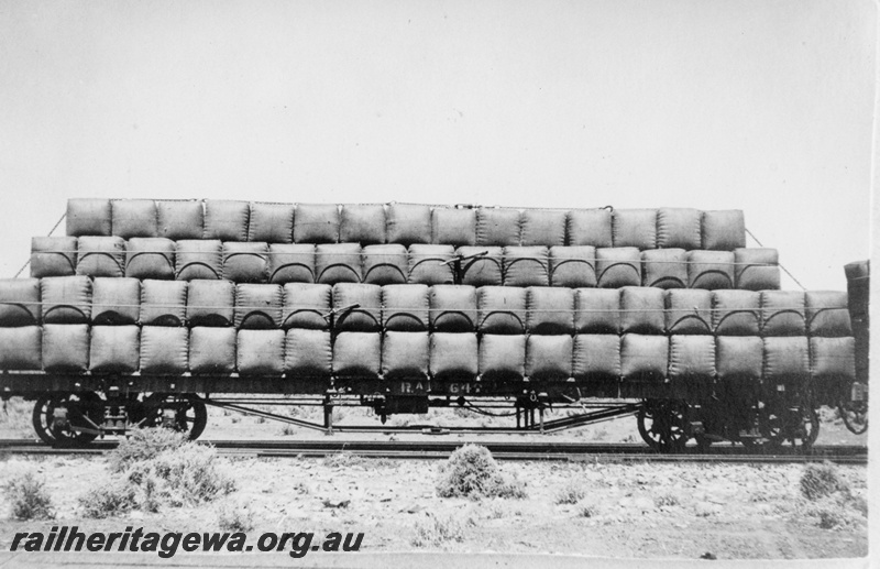 P19193
Commonwealth Railways (CR) RA class 642 flat wagon laden with wool bales, Hesso, TAR line, side view
