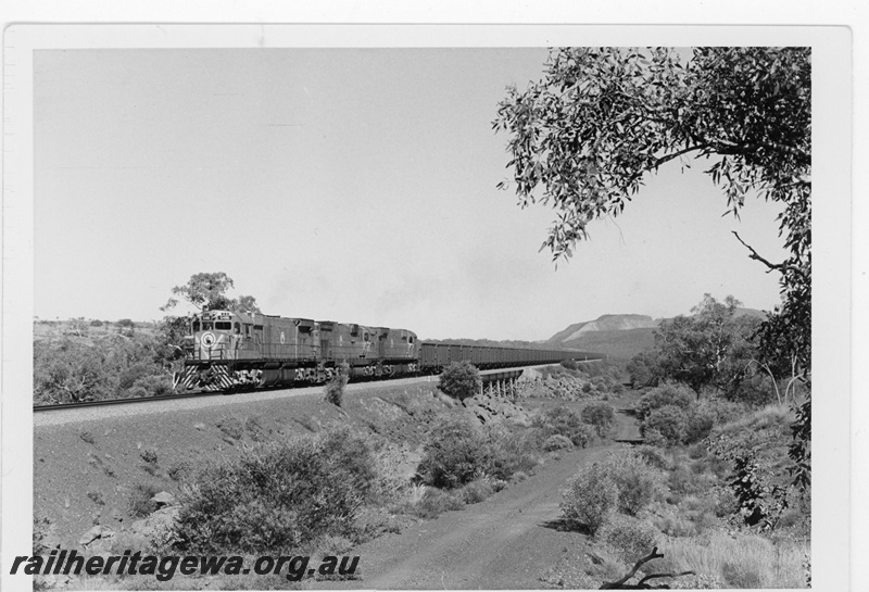 P19236
Mount Newman Mining (MNM) M636 class 5486 leads a loaded iron ore near Newman with Mount Whaleback in background.
