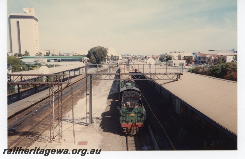P19293
W class 945 with tender leading on tour train, platforms, canopies, signals, bracket signal, signal gantries, city skyline, Perth city station, elevated view 
