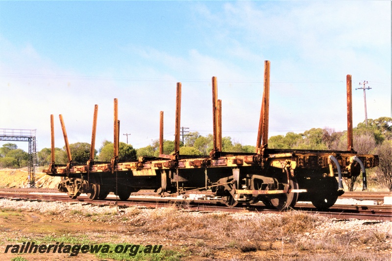 P19395
QBE class 2518 bogie flat wagon with stanchions, yellow livery, West Toodyay, side and end view
