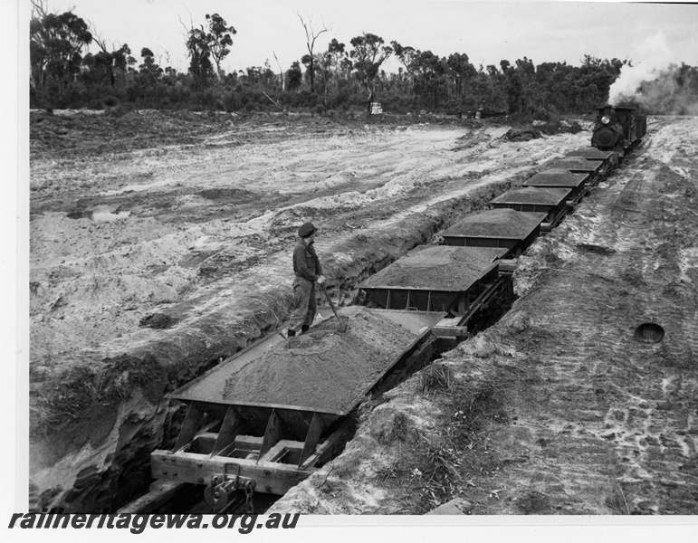 P19459
G class loco, on ballast train at loading point, worker, during construction of Nyamup to Tone River extension of Bunning Bros line
